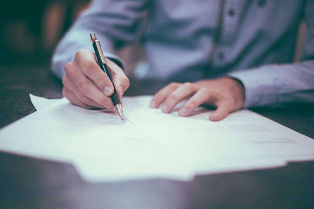 An investor filling in a mutual fund application form by hand.